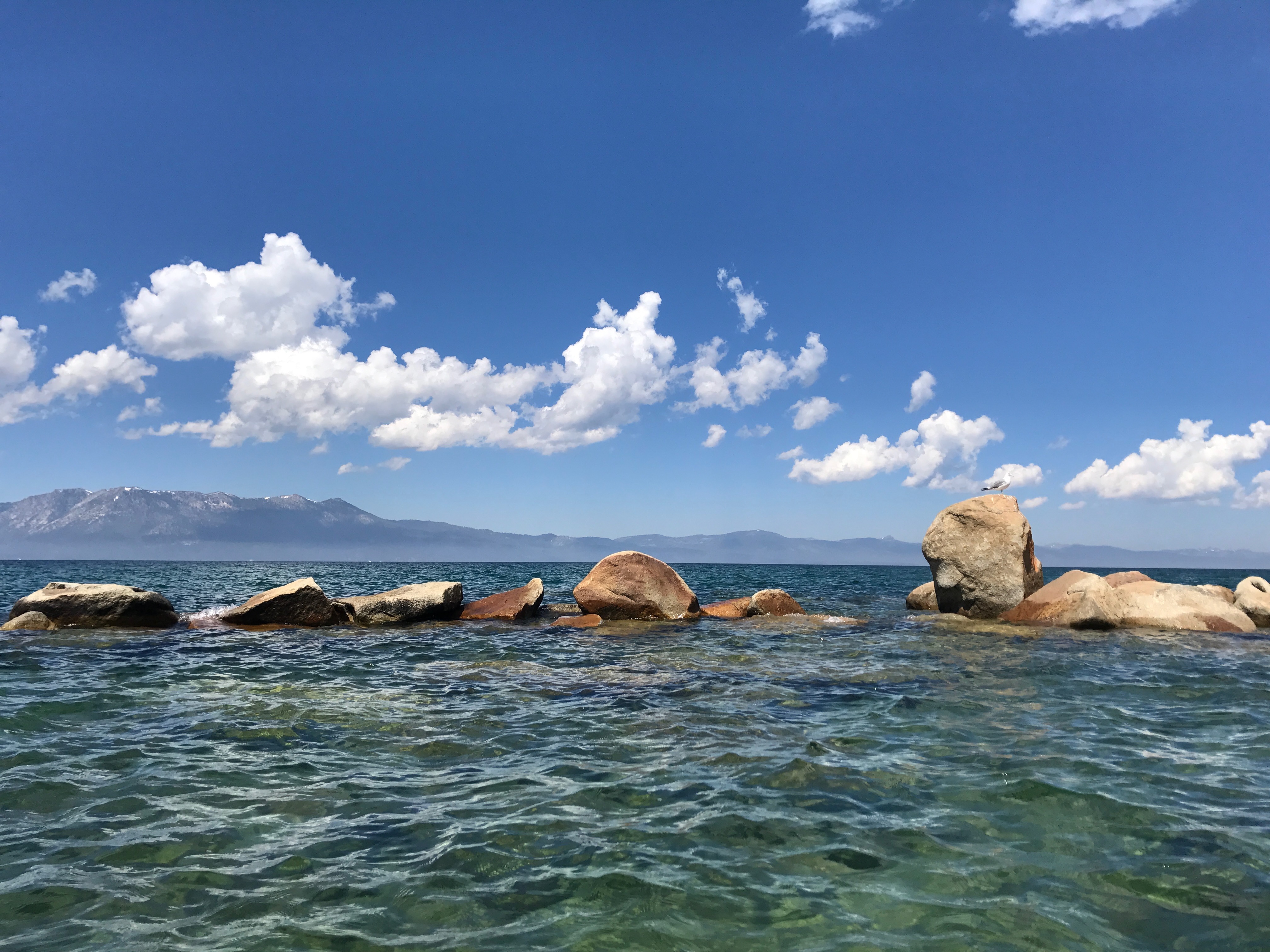 Sunlit boulders and mountain views across Lake Tahoe