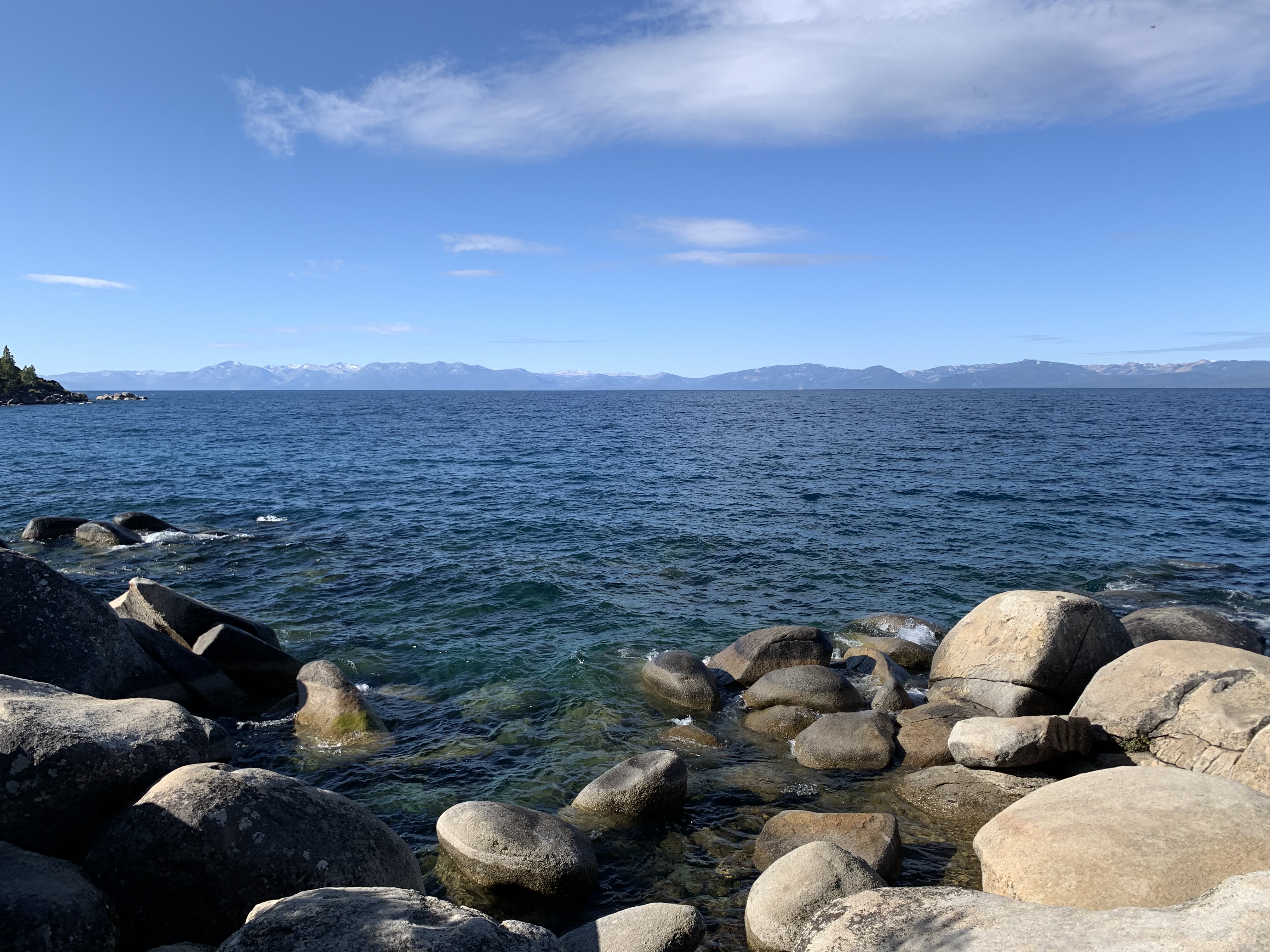 Clear Lake Tahoe water washing over shoreline boulders